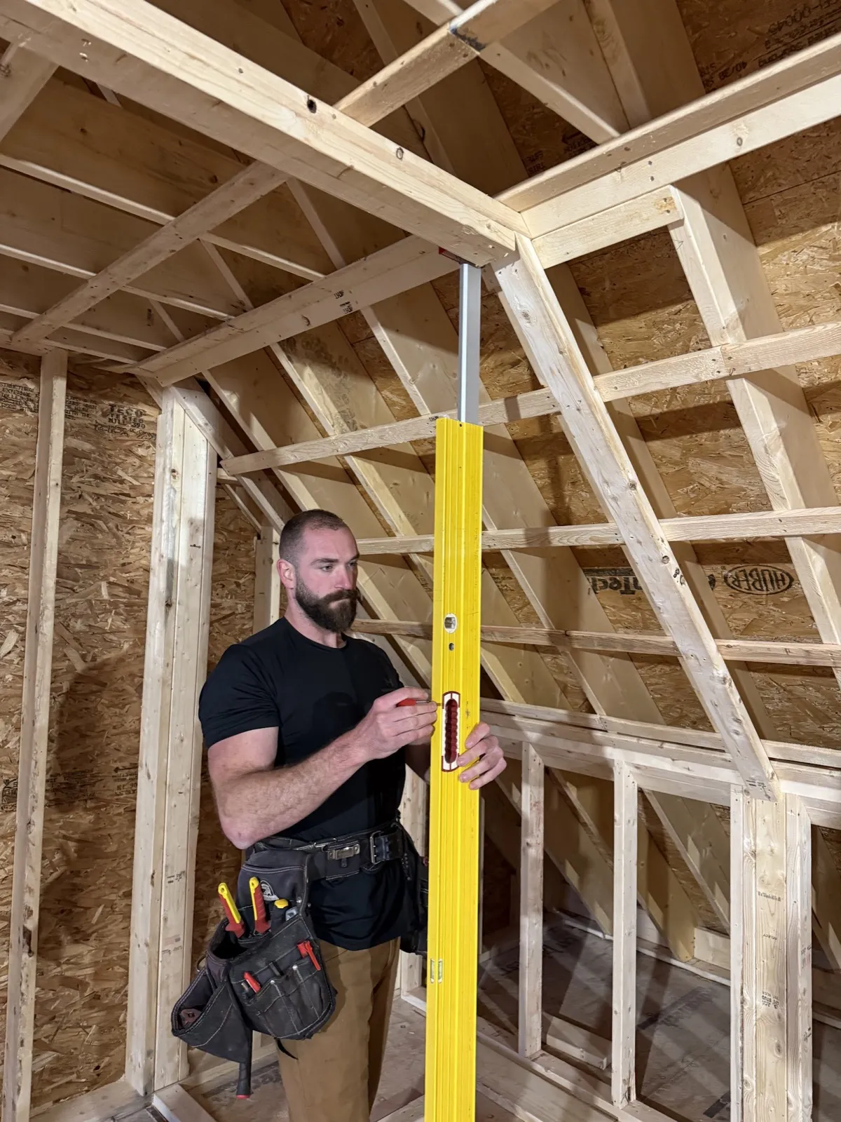 Christian Patoine checking framing with a level on a job in Maine